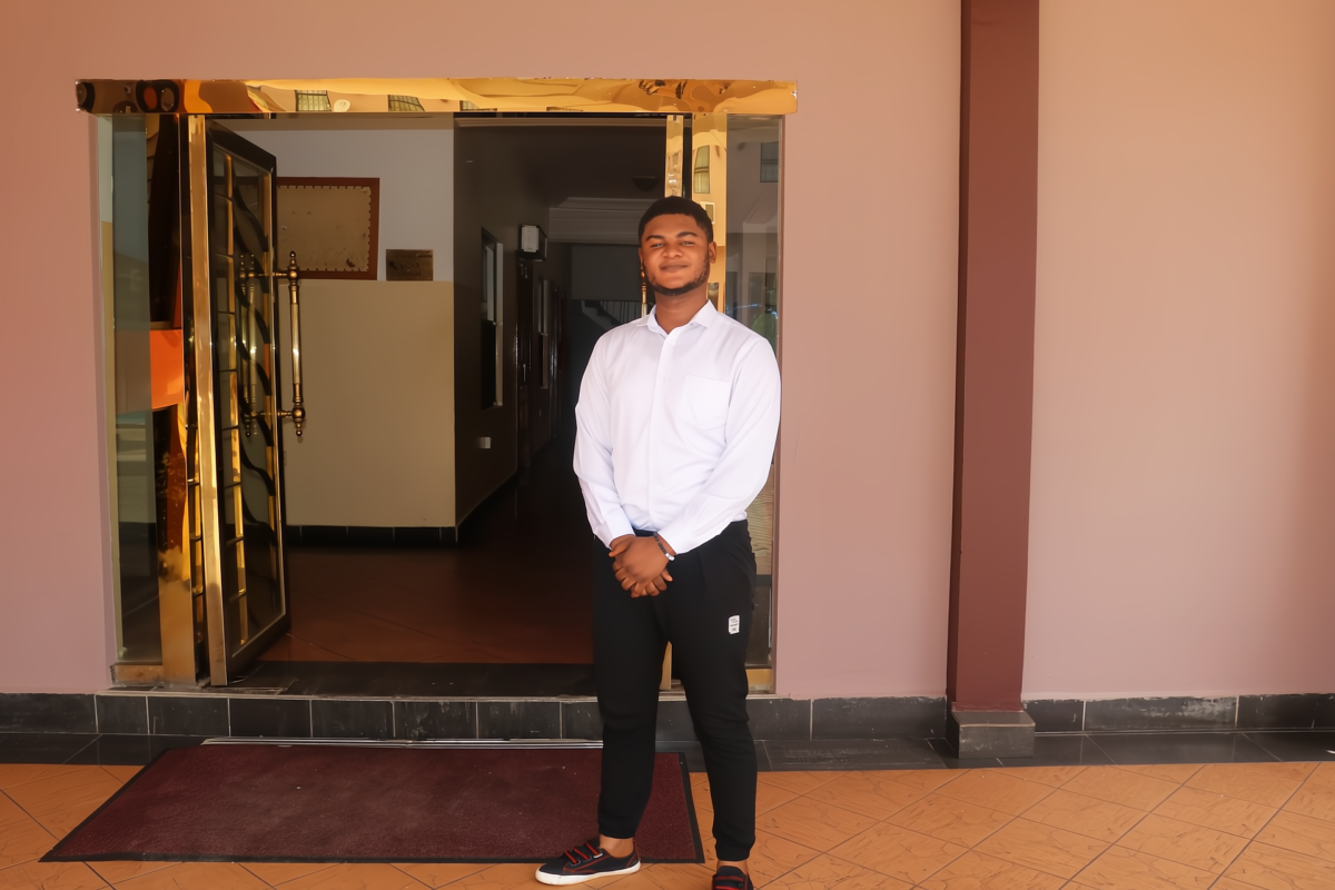 Isaac from Ghana in front of the hotel he now works at