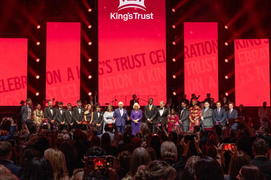 Their Majesties on stage with award winners credit The King's Trust