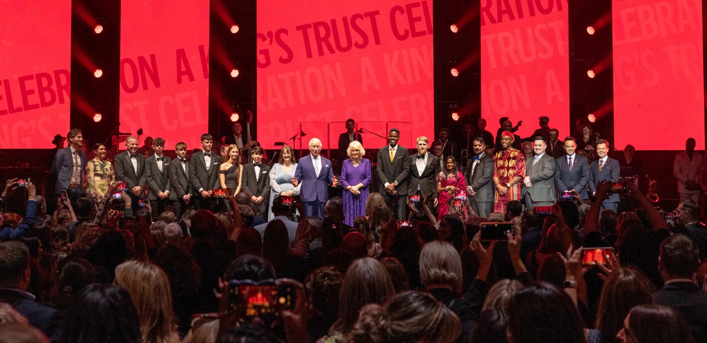 Their Majesties on stage with award winners credit The King's Trust - Harry Pseftoudis